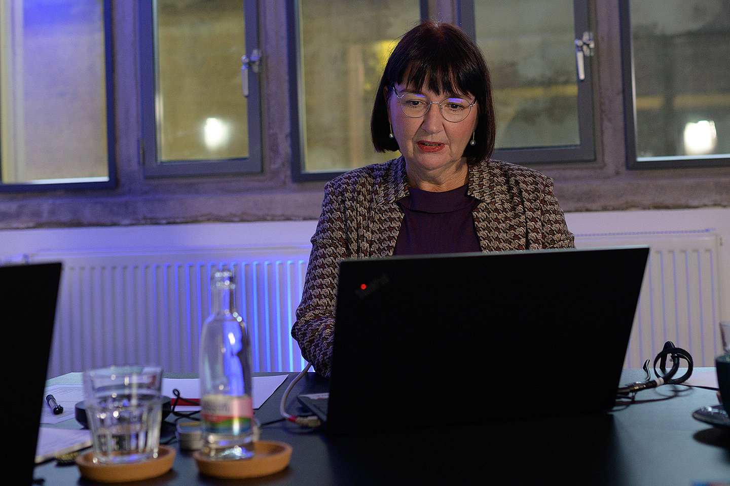 Frau Dr. Sabine Awe sitzt an einem Schreibtisch und schaut auf einen Laptop.