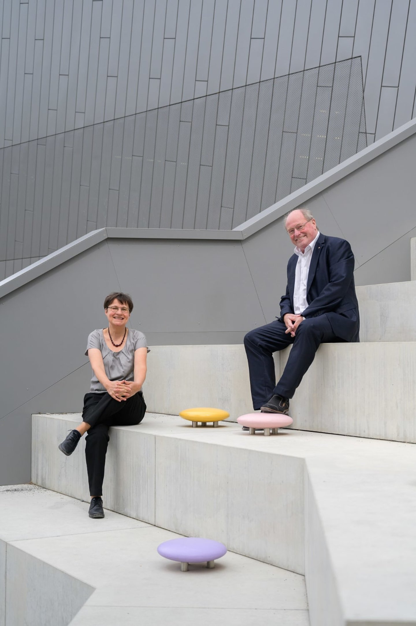 Frederike Kruse und Hans-Peter Schmitz sitzen auf großen Stufen