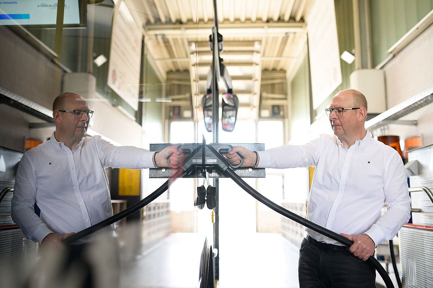 ein Busfahrer tankt seinen E-Bus mit Strom