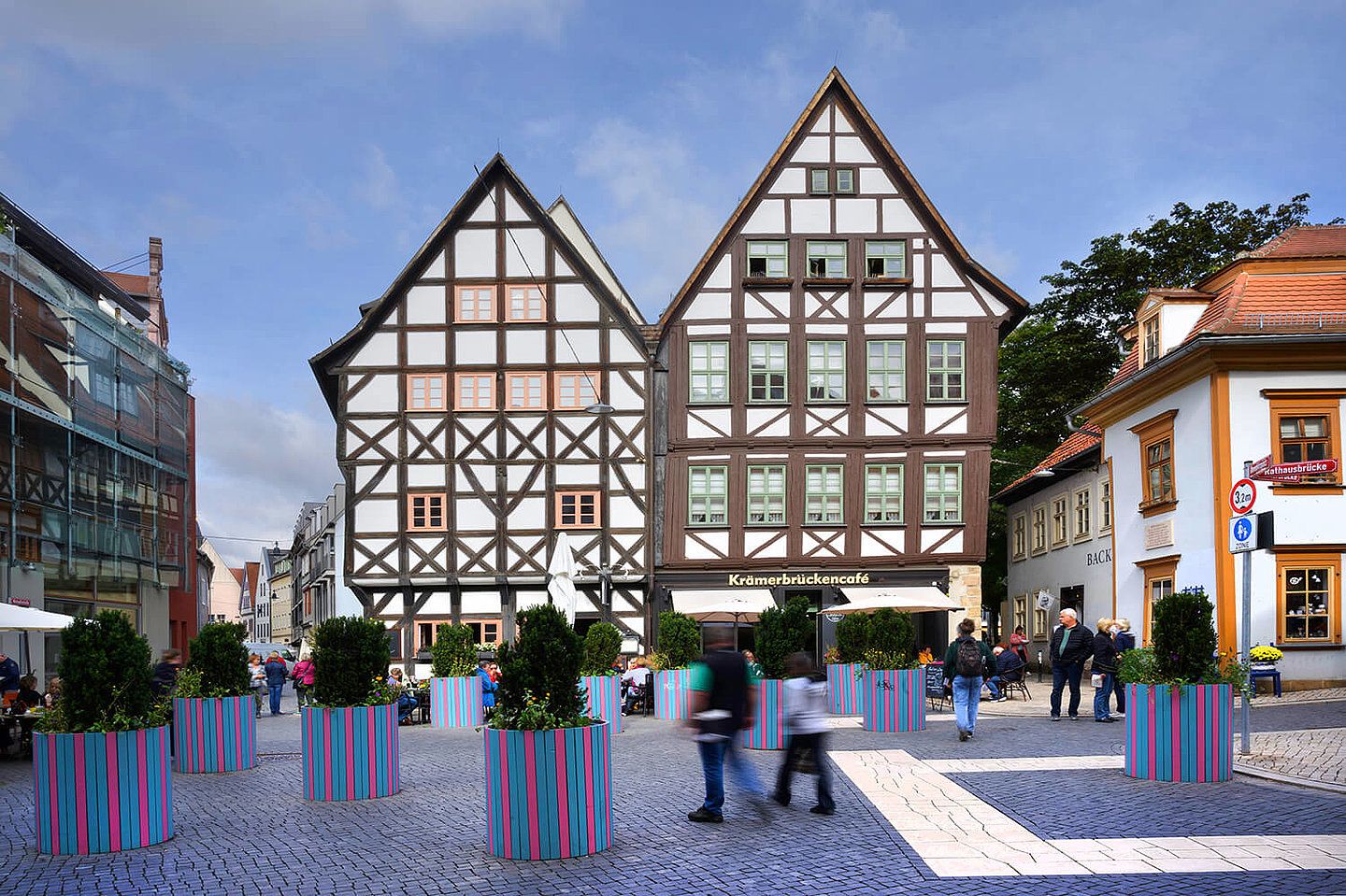 zwei alte Fachwerkhäuser an der Krämerbrücke, vor denen bepflanzte Blumenkübel stehen