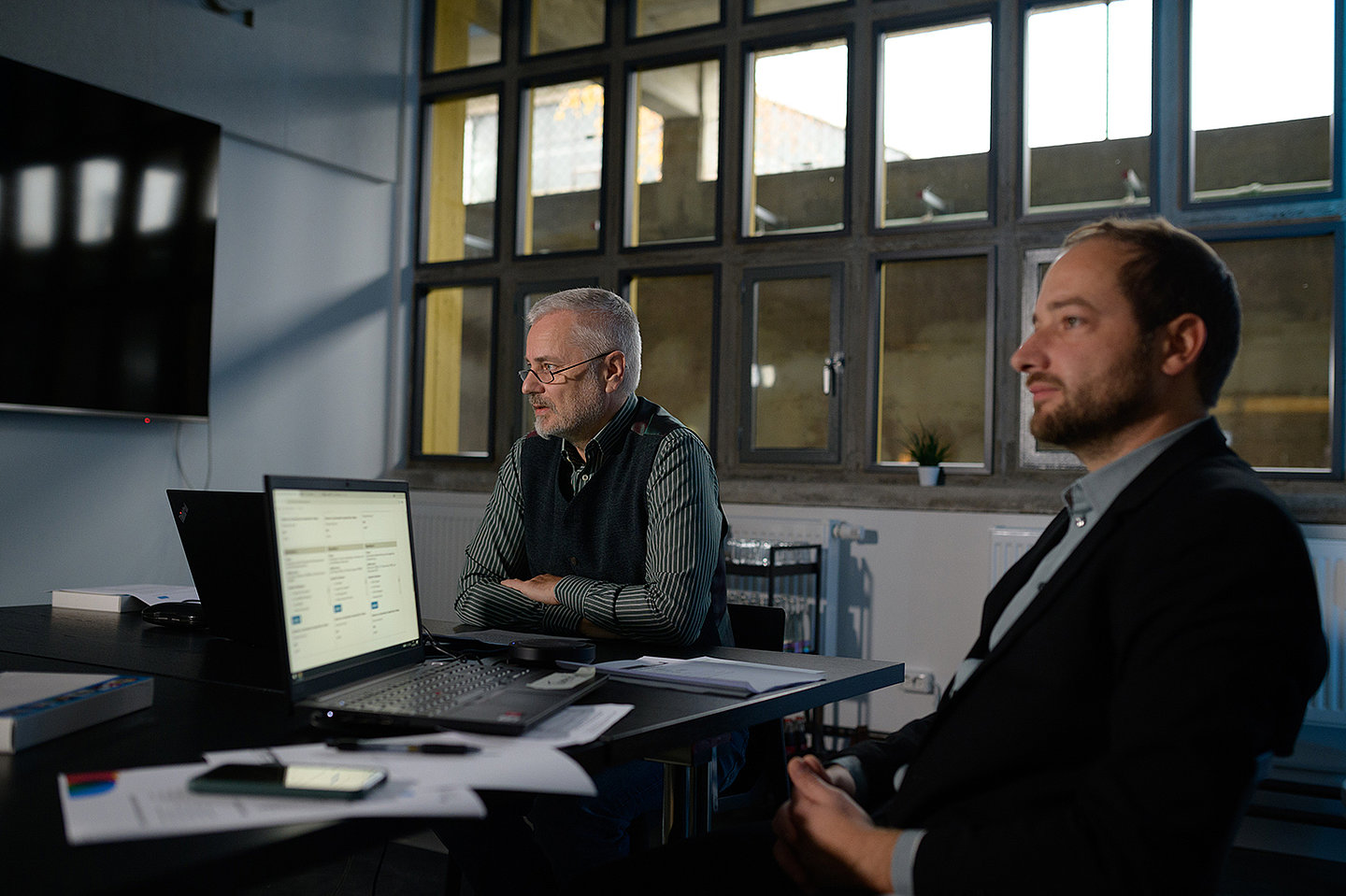 Kai Philipps (rechts) und Thomas Tappert (links) sitzen an einem Schreibtisch