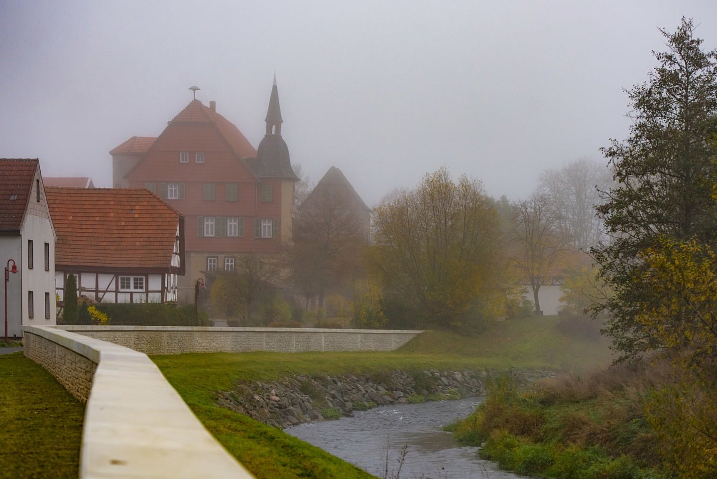 Flussbiegung mit Maueren und Häusern