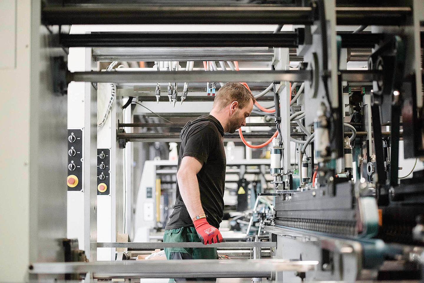 ein Mann beobachtet den Arbeitsvorgang einer Maschine