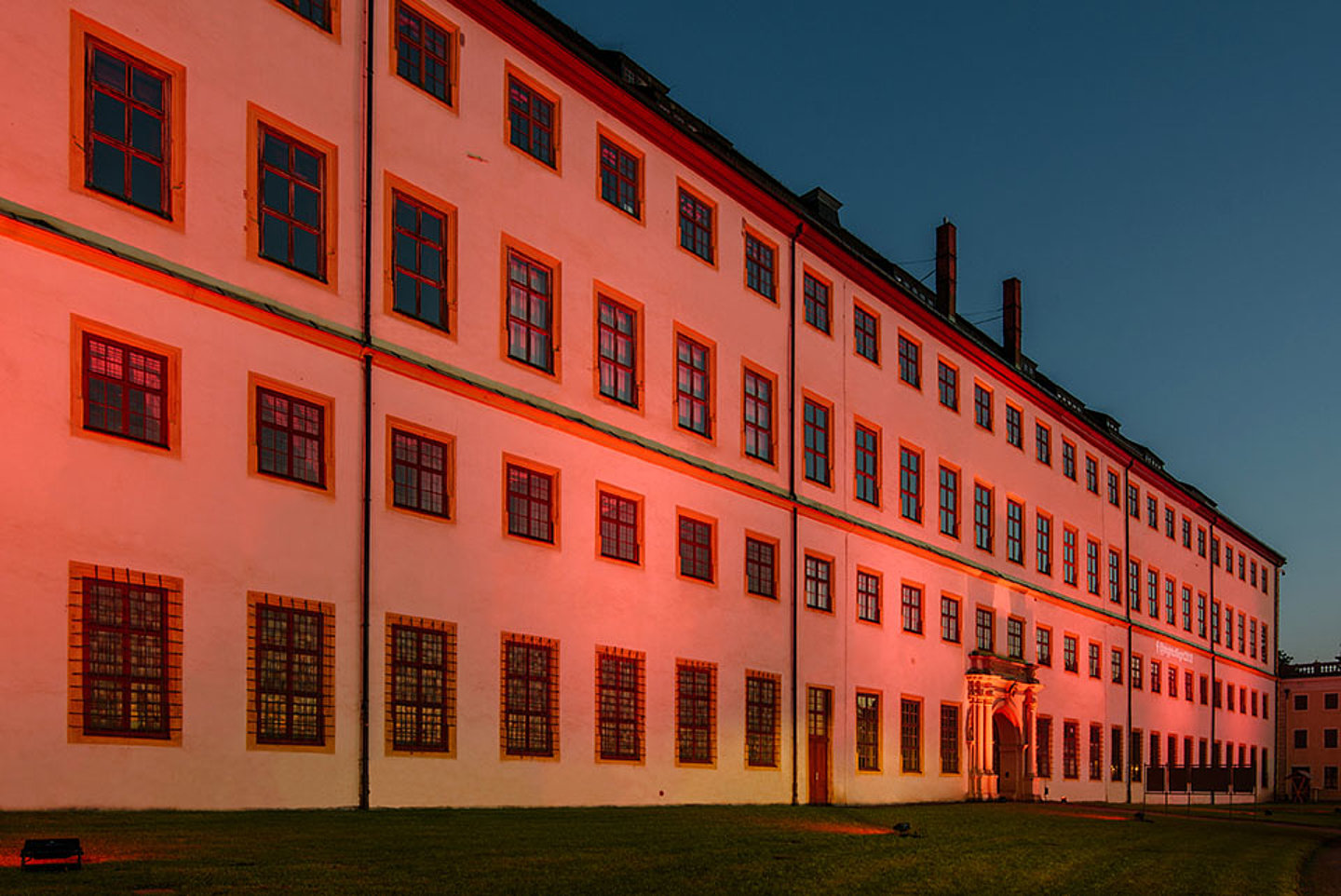 Längsseite des Schloss Friedensteins mit roter Nachtbeleuchtung