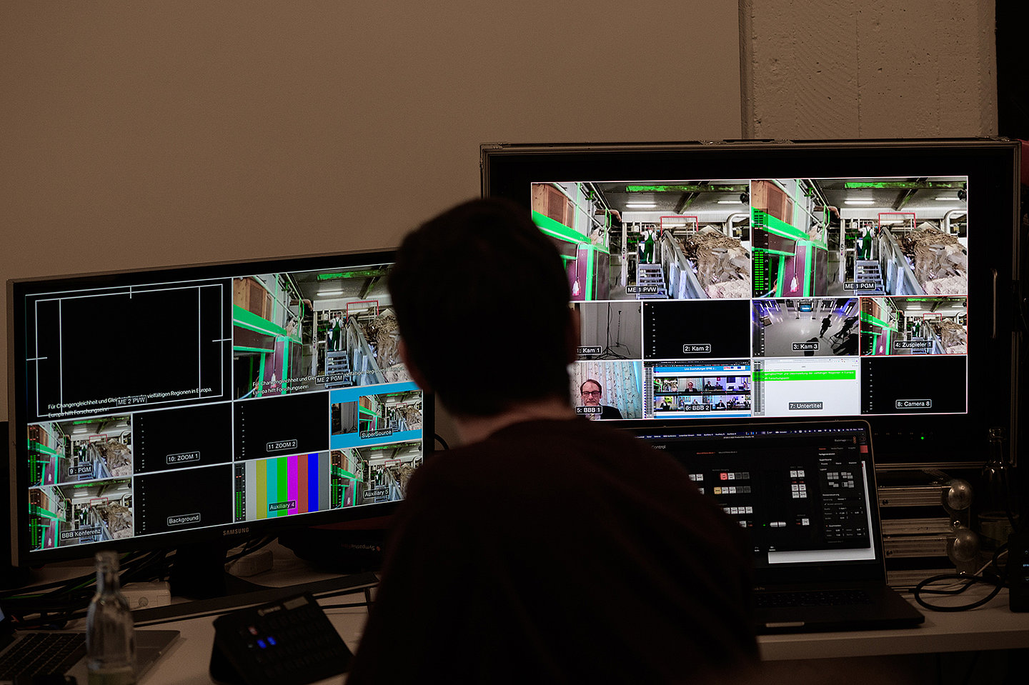 Ein Medientechniker sitzt vor 2 Monitoren.