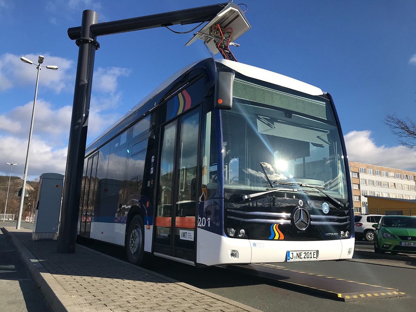 Bus an Ladestation, von leicht seitlich unten