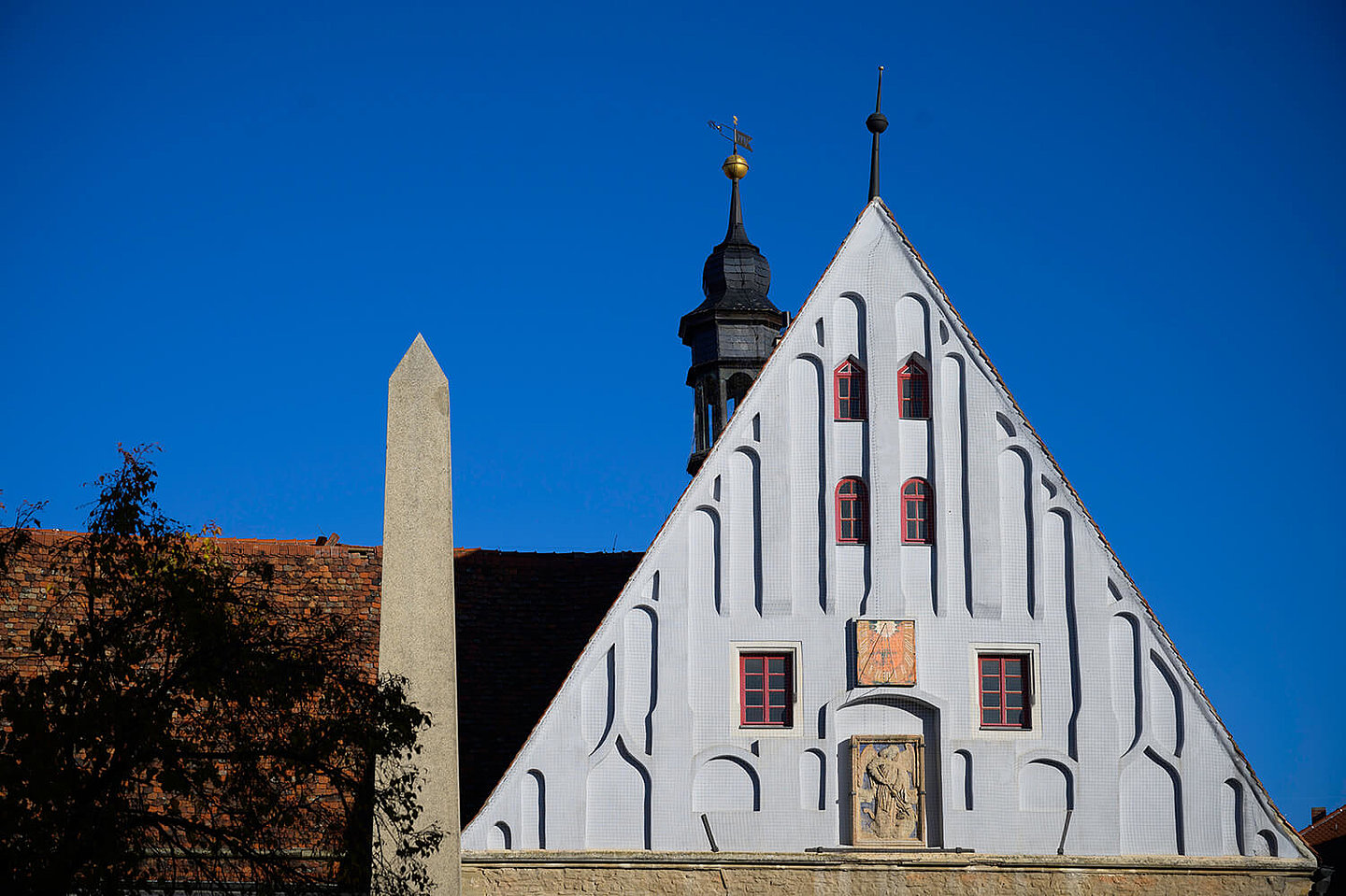 Die Giebelwand  vom Buttstaedter Rathaus mit Glockenturm und einem Obelisk.