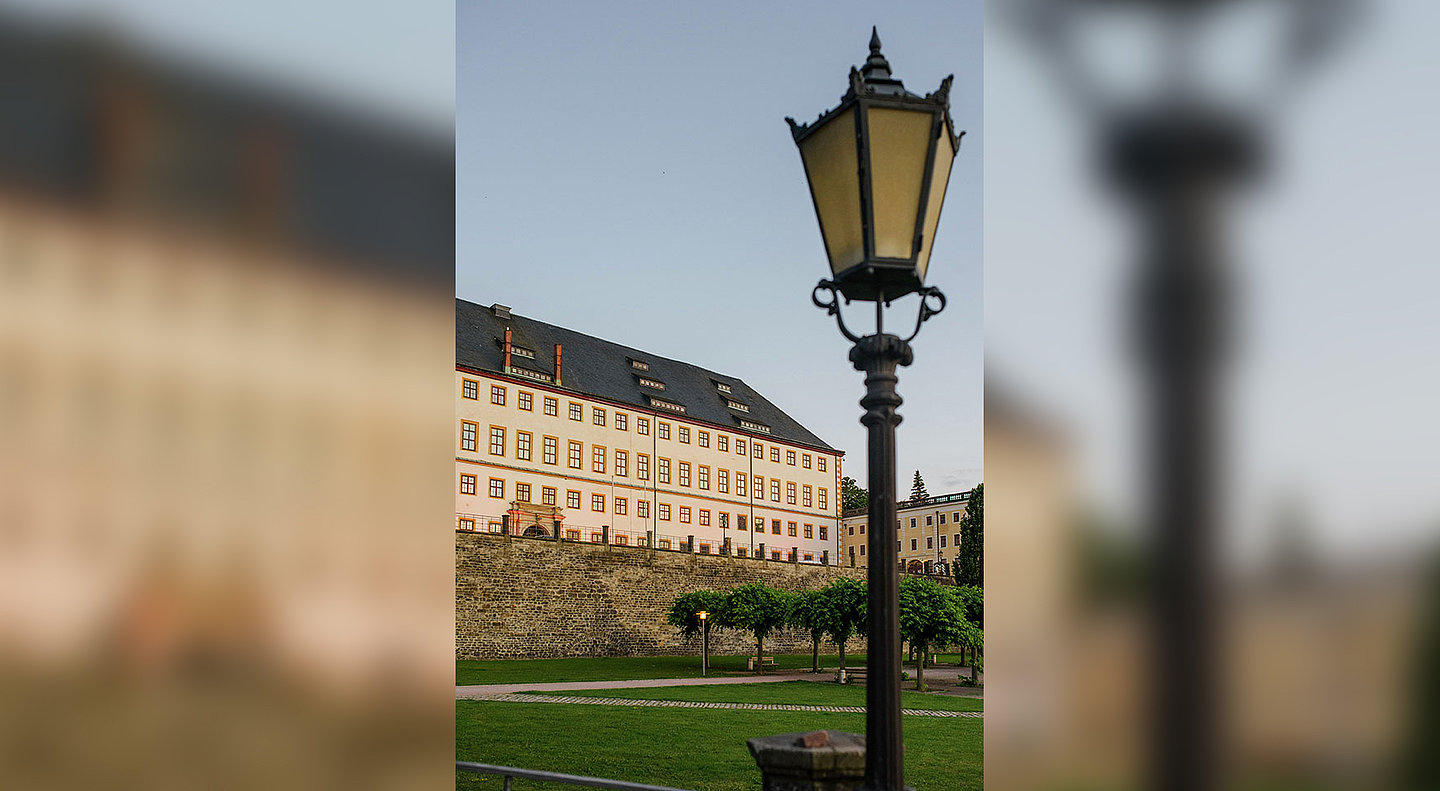 Frontansicht des Schloss Friedensteins mit historischer Laterne im Vordergrund