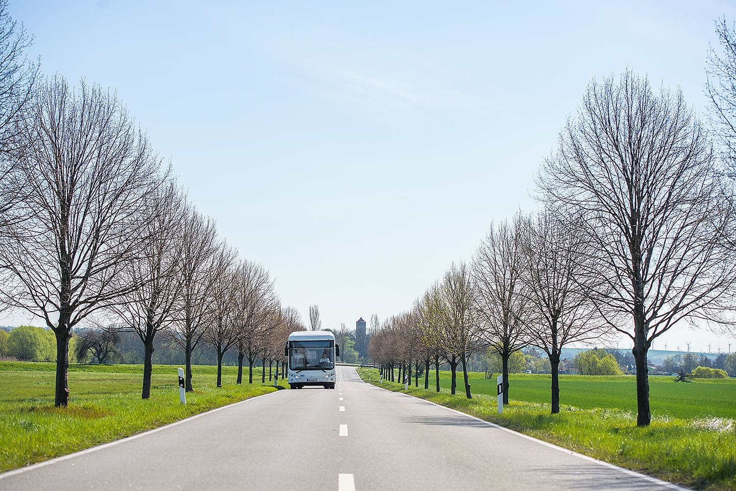 ein Bus fährt eine leere Straße auf dem Land entlang